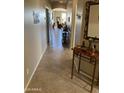 Inviting hallway featuring tiled floors, neutral walls, and decorative shelving, leading to the living area at 2662 S Springwood Blvd # 394, Mesa, AZ 85209