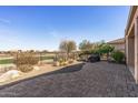 Relaxing backyard featuring a spa, desert landscaping and a paved patio at 26880 W Sierra Pinta Dr, Buckeye, AZ 85396