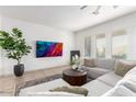 Bright living room featuring a neutral sectional sofa, a large screen TV, and lots of natural light at 9013 S 15Th Way, Phoenix, AZ 85042
