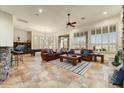 Spacious living area featuring tile floors, leather sofas, and an adjacent billiards room for entertaining at 10999 E Acoma Dr, Scottsdale, AZ 85255