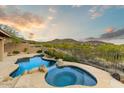 Relaxing backyard oasis with a custom pool, spa, and lush desert landscaping at 10999 E Acoma Dr, Scottsdale, AZ 85255