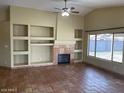 Bright living room featuring custom built-ins, fireplace, and a large window for natural light at 14930 N Gil Balcome Ct, Surprise, AZ 85379