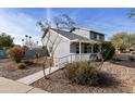 Charming gray two-story home featuring a cozy covered porch and xeriscaped front yard at 1655 W Meseto Cir, Mesa, AZ 85202