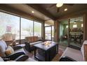 Enclosed sun room with a fire pit, comfortable seating and bright backyard views at 17662 W Cedarwood Ln, Goodyear, AZ 85338