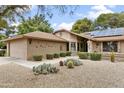 Beautiful front exterior with well-kept lawn, gravel accents, solar panels, and a two-car garage at 20215 N Medallion Ct, Sun City West, AZ 85375