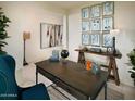 Stylish home office featuring a wood desk, eclectic decor, and ample natural light at 41905 W Hospitality Ln, Maricopa, AZ 85138