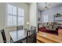 Elegant dining area with dark wood table and chairs, open to a living room, and a large window with plantation shutters at 615 E Portland St # 160, Phoenix, AZ 85004