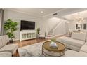 Bright living room featuring hardwood floors, a staircase, and a large-screen television at 6229 N 30Th Way, Phoenix, AZ 85016