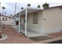 Tan home with awning and desert landscaping at 7807 E Main St # F24, Mesa, AZ 85207