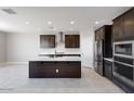 Bright kitchen featuring stainless steel appliances, dark wood cabinetry, and white countertops at 12219 W Caraveo Pl, Peoria, AZ 85383