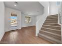 Bright entryway featuring wood floors, stairs, and a front door view of the home's exterior at 17313 W Via Dona Rd, Surprise, AZ 85387