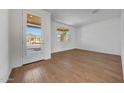Living room with wood floors and a window to the right of the front door at 17313 W Via Dona Rd, Surprise, AZ 85387