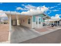 Single story home with a carport, side entrance, and covered porch with seating at 2206 S Ellsworth Rd # 149B, Mesa, AZ 85209