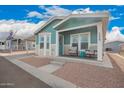 Home's inviting covered porch features cozy seating and charming blue accents at 2206 S Ellsworth Rd # 149B, Mesa, AZ 85209