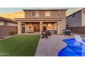 Relaxing backyard with artificial grass, a covered patio with seating, and a pool with lounge chairs at 25582 S 224Th Way, Queen Creek, AZ 85142