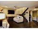 Spacious living room with cozy seating, modern ceiling fan, and staircase to upper level at 3030 N Hayden Rd # 28, Scottsdale, AZ 85251