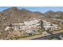 Gorgeous aerial view of desert community with mountain views, a tennis court, and community pool at 3800 E Lincoln Dr # 7, Phoenix, AZ 85018