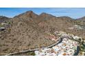 Majestic aerial view of desert residences nestled against a backdrop of rugged mountains and clear sky at 3800 E Lincoln Dr # 7, Phoenix, AZ 85018