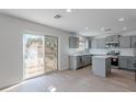 Modern kitchen featuring gray cabinets, stainless steel appliances, and a sliding door leading to the backyard at 3917 E Morenci Rd, San Tan Valley, AZ 85143