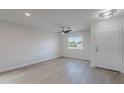 Bright, empty living room with wood-look flooring, a ceiling fan, and a large window overlooking the neighborhood at 3917 E Morenci Rd, San Tan Valley, AZ 85143