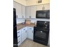 Classic kitchen with white cabinets, black appliances, granite countertops, and wood-look floors at 4537 N 26Th Dr, Phoenix, AZ 85017