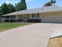Inviting single-level home with a long driveway leading to an attached two car garage at 4909 E Osborn Rd, Phoenix, AZ 85018