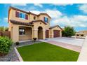 Inviting front exterior with stucco, tile roof, three-car garage, lawn and stone accents at 7975 W Andrea Dr, Peoria, AZ 85383