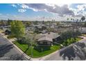 A scenic aerial view of a corner lot home with mature trees, circular drive, manicured lawn, and welcoming curb appeal at 801 W Tyson St, Chandler, AZ 85225