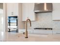 Bright kitchen featuring white cabinets, stainless steel appliances, and gold fixtures at 1254 E Penedes Dr, Gilbert, AZ 85298