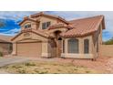 Two-story stucco home with a tile roof, attached two-car garage, and covered entryway at 12574 W Desert Rose Rd, Avondale, AZ 85392