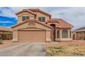Two-story home with a tile roof, two-car garage, desert landscaping and an arched entryway at 12574 W Desert Rose Rd, Avondale, AZ 85392