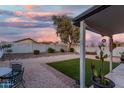 Spacious backyard with gravel landscaping, desert foliage, and a covered patio perfect for entertaining at 12630 W Aster Dr, El Mirage, AZ 85335