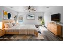 Inviting main bedroom featuring natural light, neutral walls, sleek wood-look floors, and a modern ceiling fan at 1321 E Pedro Rd, Phoenix, AZ 85042