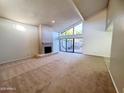 Open living room with vaulted ceilings, a fireplace, and sliding glass doors to the patio at 1606 E Cactus Wren Dr, Phoenix, AZ 85020