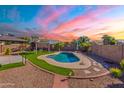 An outdoor oasis featuring a private swimming pool and lush artificial turf area at 16671 W Mckinley St, Goodyear, AZ 85338