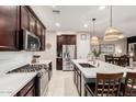 Modern kitchen with stainless steel appliances, white countertops, and dark wood cabinets at 17938 W Cedarwood Ln, Goodyear, AZ 85338