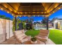 Inviting backyard featuring a pool with slide and covered seating area with comfortable chairs at 1825 N Granite Reef Rd, Scottsdale, AZ 85257