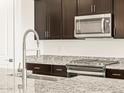 Close-up showcasing granite countertops, stainless steel appliances, and modern fixtures in this well-appointed kitchen at 24612 W Grenadine Rd, Buckeye, AZ 85326