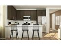 Modern kitchen featuring stainless steel appliances, dark cabinetry, and a breakfast bar at 25128 N 173Rd Dr, Surprise, AZ 85387
