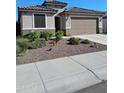 Charming single-story home featuring a two car garage and desert landscaping at 26947 W Adam Ave, Buckeye, AZ 85396