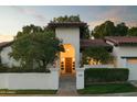 Inviting front entrance with mature trees and a warm light shining through the front door at 3140 E Claremont Ave, Phoenix, AZ 85016