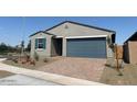 Single-story home featuring a two-car garage and desert landscaping with flowering bushes at 3822 S 87Th Dr, Tolleson, AZ 85353