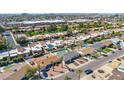 An aerial view featuring the neighborhood with tile roofs, palm trees, green lawns, and community amenities at 7923 E Palm Ln, Scottsdale, AZ 85257