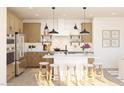 Bright kitchen with white countertops, island with seating, wood cabinets and modern stainless steel appliances at 7976 W Griswold Rd, Peoria, AZ 85345