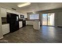 Bright kitchen featuring a black appliance suite, white cabinets, and a convenient kitchen island at 808 N 67Th Ln, Phoenix, AZ 85043