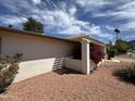The home's front exterior with blooming bougainvillea accenting the stucco walls and pergola feature at 9059 N Arroya Grande Dr, Phoenix, AZ 85028