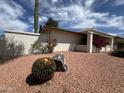 Landscaped front yard featuring desert flora, including barrel cactus, complemented by decorative gravel at 9059 N Arroya Grande Dr, Phoenix, AZ 85028