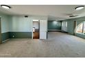 Open living room featuring neutral carpet, ceiling fan, view to the kitchen and front entry at 9059 N Arroya Grande Dr, Phoenix, AZ 85028
