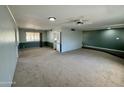 Spacious carpeted living room with large window, ceiling fan, and two-tone neutral paint at 9059 N Arroya Grande Dr, Phoenix, AZ 85028