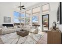 Bright living room with high ceilings, large windows, neutral furniture, and tile floors offering a modern, comfortable space at 11097 Quinn Dr, Goodyear, AZ 85338